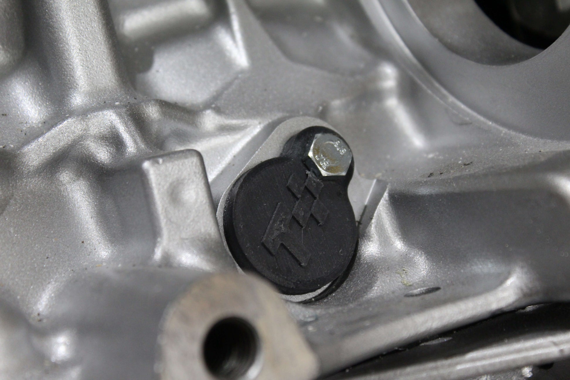 Close-up of an injector port cover installed on an engine, showcasing automotive maintenance part quality.